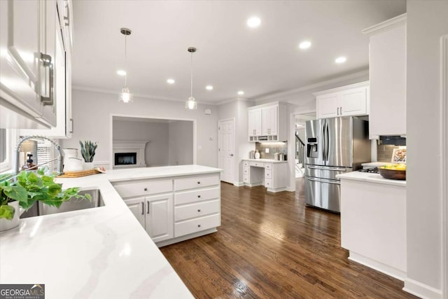 kitchen featuring decorative backsplash, ornamental molding, white cabinets, a sink, and stainless steel fridge with ice dispenser