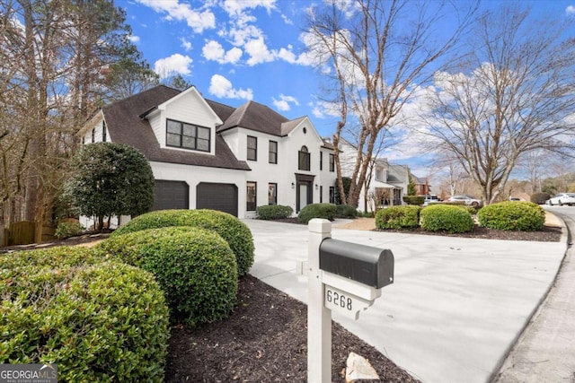 view of front facade with driveway, a shingled roof, an attached garage, and a residential view