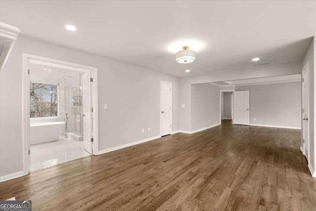 unfurnished living room with recessed lighting, visible vents, baseboards, and wood finished floors