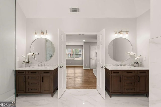 bathroom with two vanities, marble finish floor, visible vents, and a sink