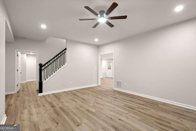 unfurnished living room with baseboards, visible vents, wood finished floors, stairs, and recessed lighting