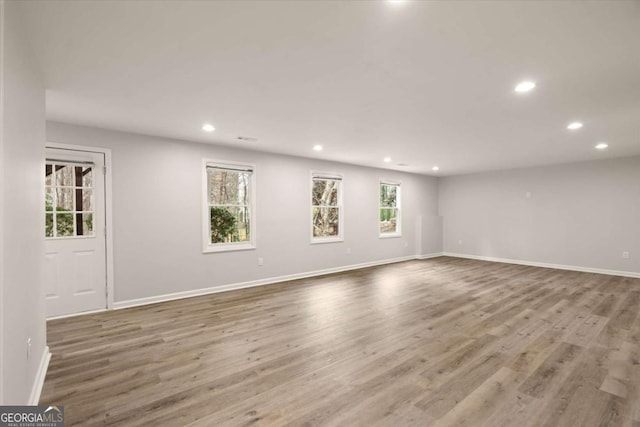 spare room with baseboards, wood finished floors, and recessed lighting