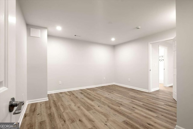 empty room featuring recessed lighting, baseboards, and wood finished floors