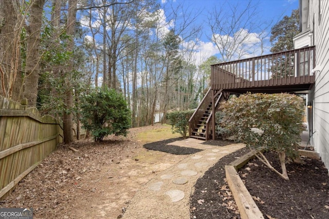 view of yard with stairs, a deck, and fence