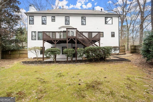 back of property featuring a patio area, fence, a deck, and a lawn