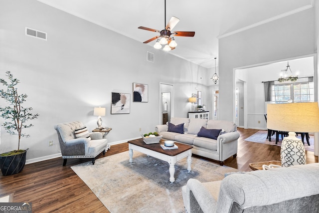 living area with baseboards, visible vents, wood finished floors, and ornamental molding