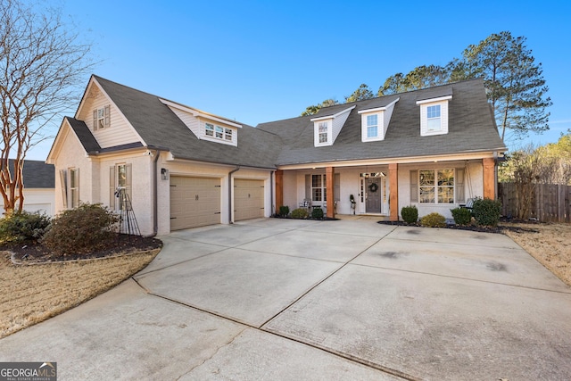 view of front of home featuring a garage, covered porch, brick siding, fence, and concrete driveway