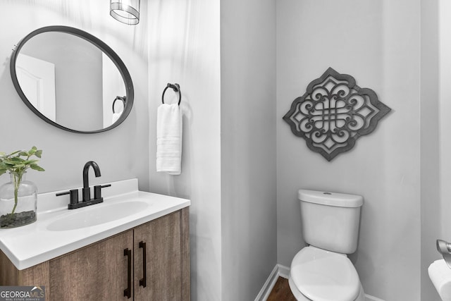 bathroom with vanity, toilet, and baseboards