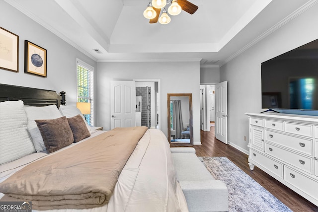 bedroom featuring visible vents, a tray ceiling, and dark wood-style flooring