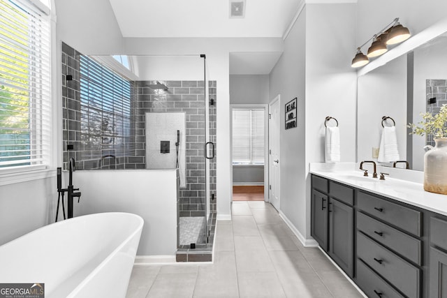 full bathroom with visible vents, a stall shower, vanity, a freestanding tub, and tile patterned floors