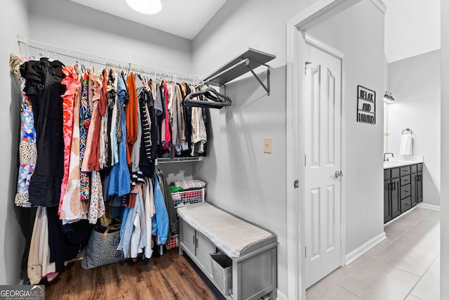 walk in closet with light wood-type flooring and a sink