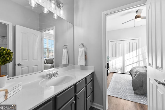 full bath featuring baseboards, a ceiling fan, connected bathroom, wood finished floors, and vanity