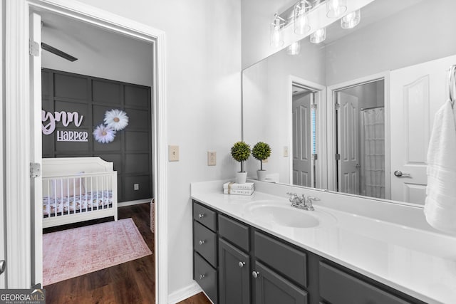 full bathroom featuring baseboards, wood finished floors, and vanity