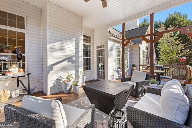 wooden terrace with outdoor lounge area and a ceiling fan