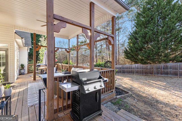 wooden deck featuring a grill and fence