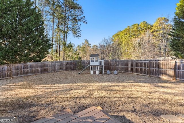 view of yard with a playground and a fenced backyard