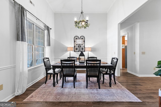 dining area featuring a chandelier, visible vents, ornamental molding, and wood finished floors