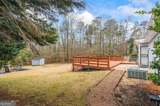 view of yard featuring an outbuilding, a storage unit, central AC unit, and a wooden deck