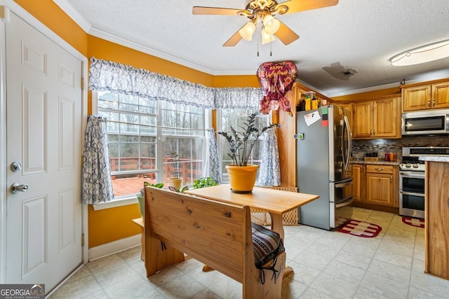 kitchen featuring decorative backsplash, ceiling fan, appliances with stainless steel finishes, brown cabinets, and crown molding