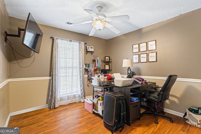 office space with ceiling fan, a textured ceiling, wood finished floors, and baseboards