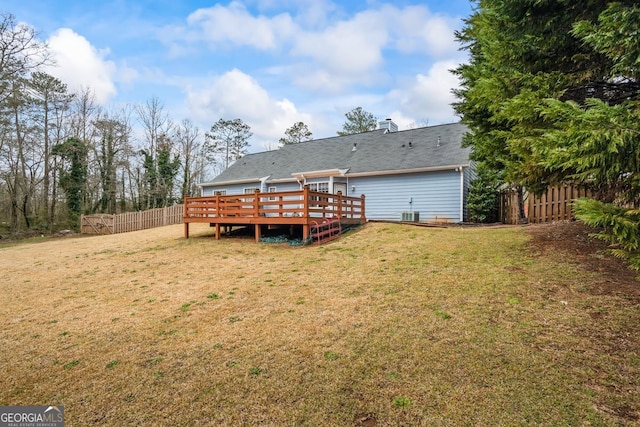 rear view of house featuring a yard, fence, cooling unit, and a wooden deck