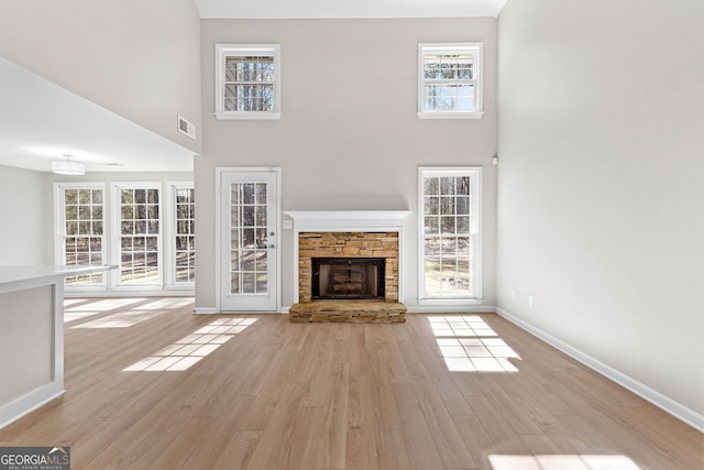 unfurnished living room with plenty of natural light, a fireplace, and wood finished floors