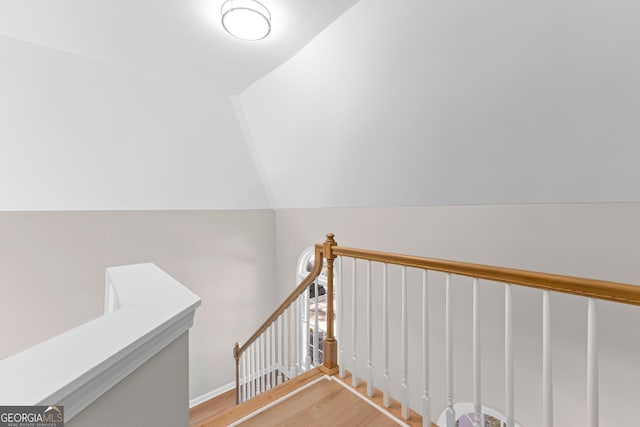 stairway with vaulted ceiling and wood finished floors