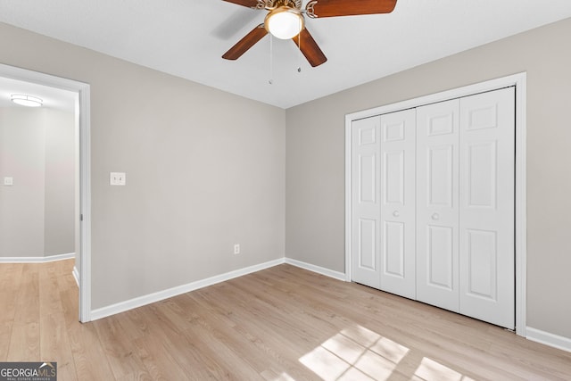 unfurnished bedroom featuring light wood finished floors, a closet, and baseboards