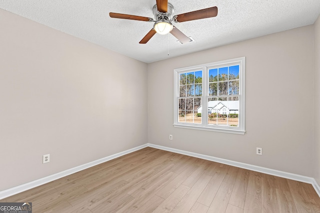 unfurnished room with baseboards, ceiling fan, a textured ceiling, and light wood finished floors