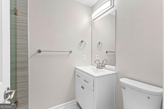 bathroom with vanity, toilet, and baseboards