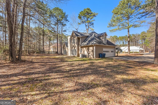 view of property exterior with driveway, a garage, and a lawn