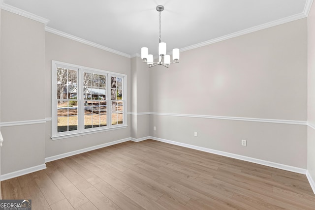 unfurnished dining area with an inviting chandelier, light wood-style flooring, and crown molding