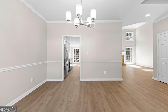 unfurnished dining area featuring light wood-style floors, baseboards, ornamental molding, and a wealth of natural light