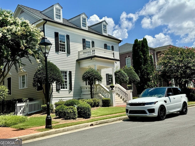 view of front facade featuring a balcony and fence