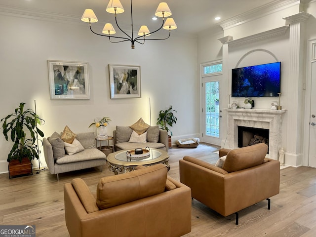 living room featuring ornamental molding, a fireplace, light wood-style floors, and baseboards