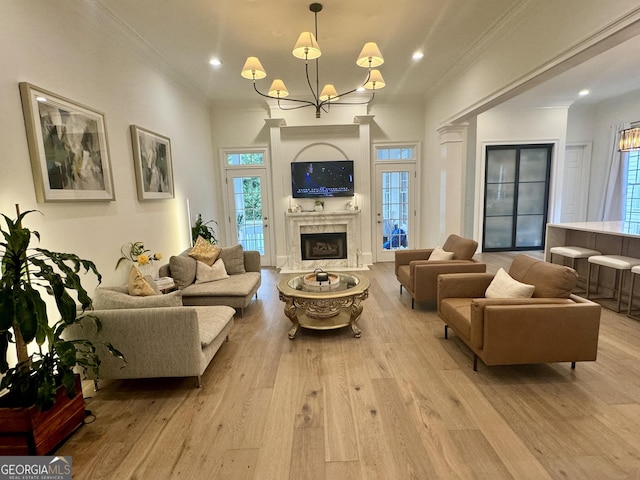 interior space with an inviting chandelier, crown molding, a premium fireplace, and wood finished floors