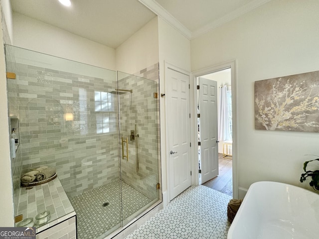 full bathroom featuring ornamental molding, a soaking tub, a shower stall, and baseboards