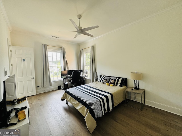 bedroom with baseboards, visible vents, ceiling fan, wood finished floors, and crown molding