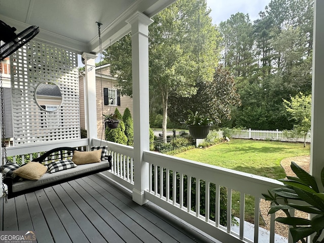 wooden deck featuring a yard and fence