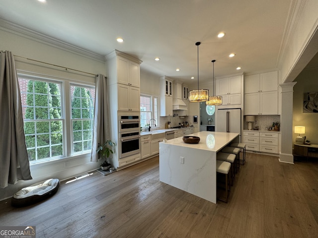 kitchen with white cabinetry, appliances with stainless steel finishes, dark wood finished floors, and crown molding