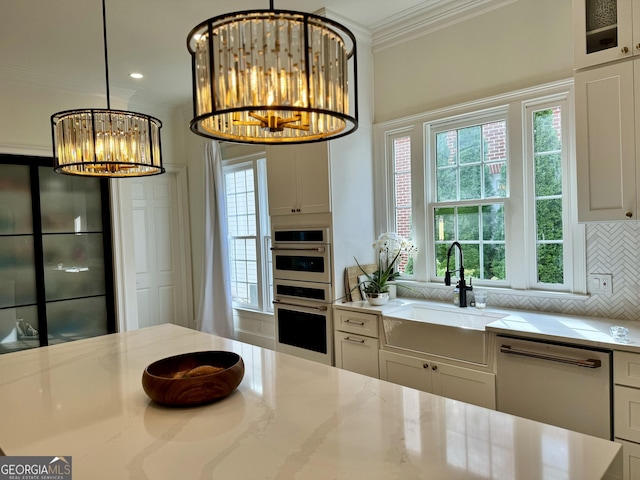 kitchen with crown molding, a notable chandelier, decorative backsplash, a sink, and white appliances