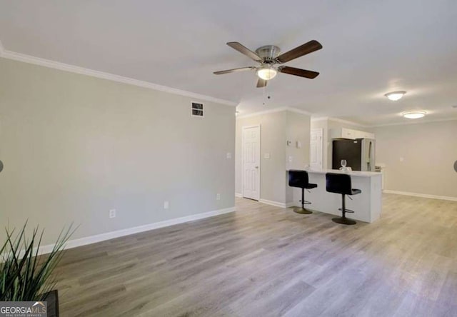 unfurnished living room featuring light wood-style floors and crown molding