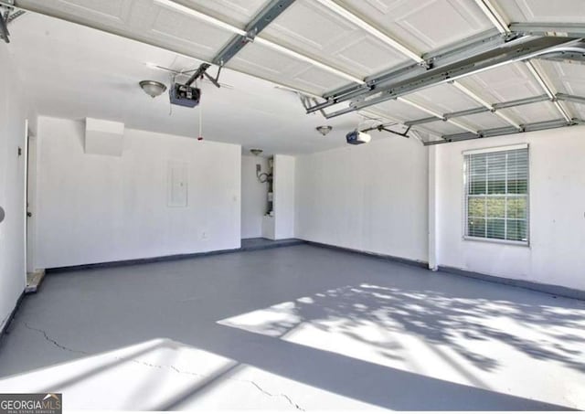 garage featuring electric panel, baseboards, and a garage door opener