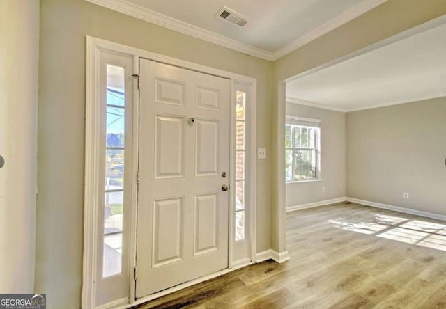 entrance foyer with visible vents, baseboards, wood finished floors, and crown molding