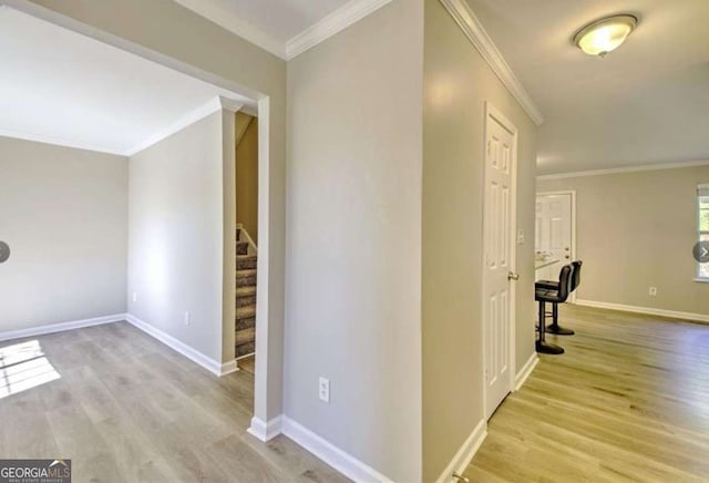 hall with stairway, crown molding, baseboards, and wood finished floors