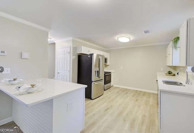 kitchen featuring ornamental molding, a peninsula, electric stove, stainless steel fridge, and a sink