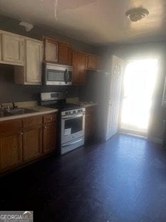 405 Fairburn Rd SW Unit 107, Atlanta, GA 30331 - kitchen featuring stainless steel microwave, gas range oven, brown cabinets, and light countertops