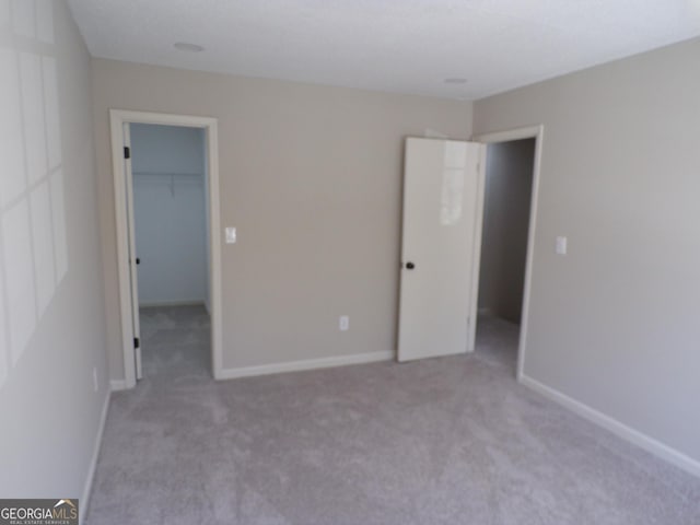 2401 Northlake Ct, Atlanta, GA 30345 - unfurnished bedroom with a spacious closet, a closet, light carpet, and baseboards