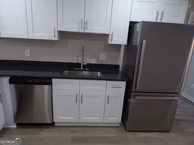 2401 Northlake Ct, Atlanta, GA 30345 - kitchen featuring a sink, dark stone countertops, stainless steel appliances, light wood-style floors, and white cabinets