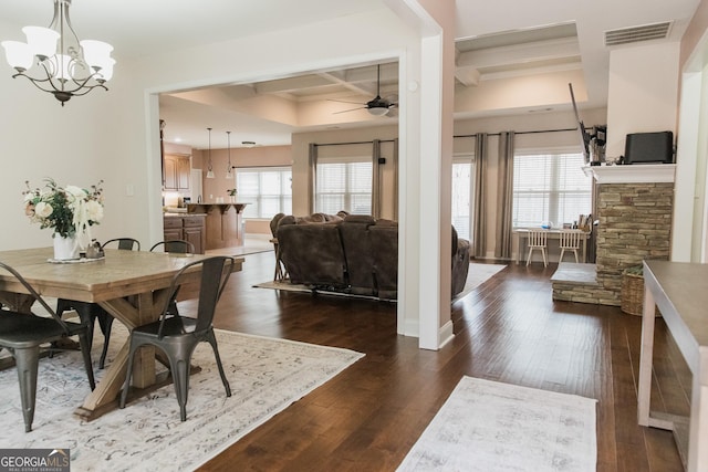 dining area with a wealth of natural light, dark wood-type flooring, coffered ceiling, and visible vents